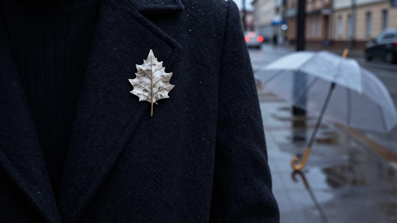 Винтажная брошь в виде березового листа на темном пальто с отражением прозрачного зонта в луже.