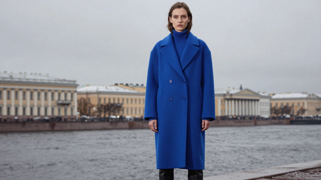 Яркое пальто цвета кобальтового синего на фоне серого города
